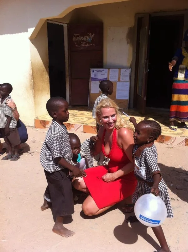 Angélique tussen lachende kleuters bij een school in Gambia