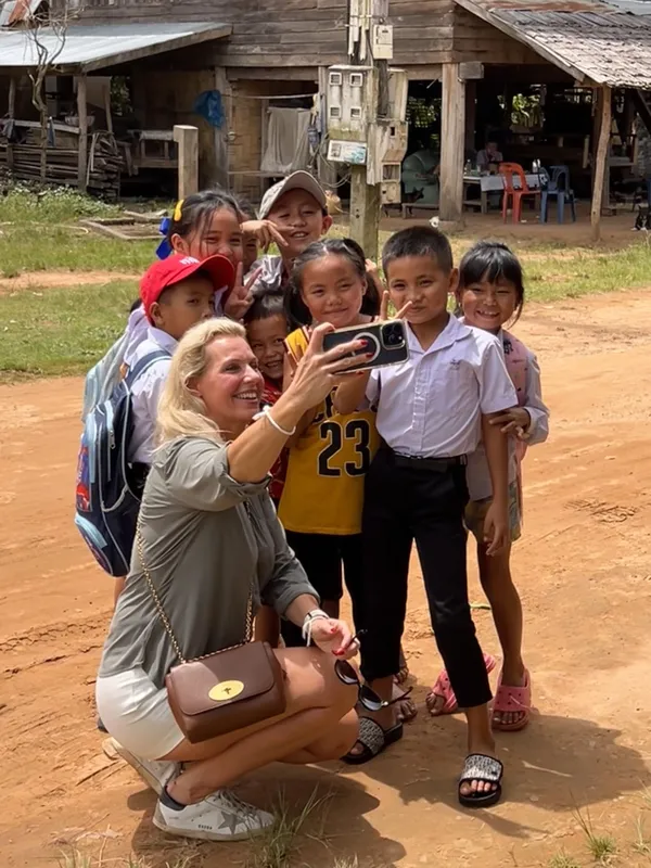Angélique maakt een selfie met een groep kinderen in een dorp in Laos